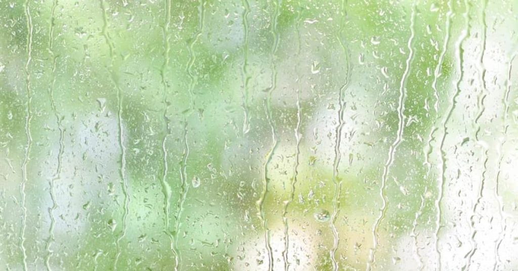 雨に打たれる窓の写真